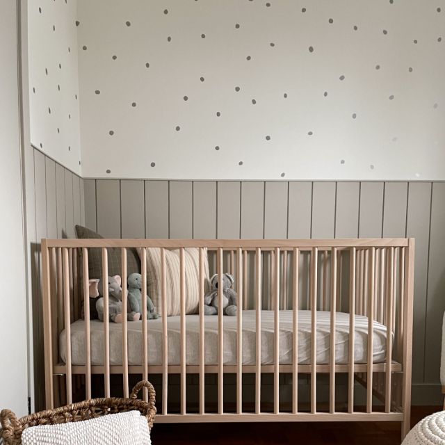A sweet nursery for a little boy, featuring soft tones, cozy textures, and vertical shiplap that provides timeless character.